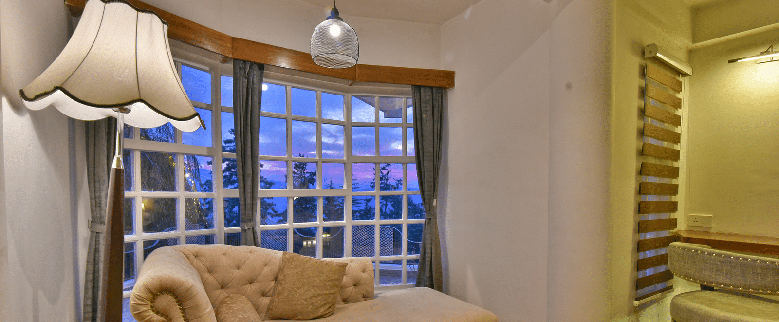 A living area of a suite featuring a sofa and a floor lamp at DLS Hillcrest Resort, Shimla.